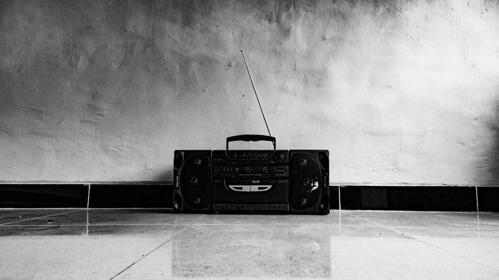 Fotografía en blanco y negro de una radio antigua puesta en el suelo.
