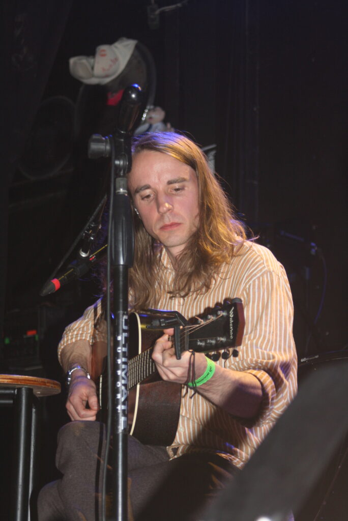Andy Shauf tocando guitarra acústica close up